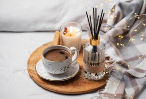 bambou des bâtons dans bouteille avec parfumé bougies et tasse de café photo