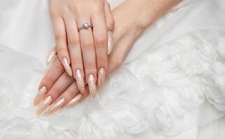 main de une Jeune femme avec blanc perle manucure photo