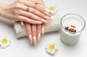 main de une Jeune femme avec blanc perle manucure photo