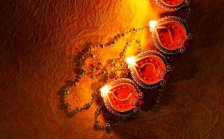 joyeux diwali - lampes diya allumées pendant la célébration de diwali. Des lanternes colorées et décorées sont allumées la nuit à cette occasion avec des rangoli de fleurs, des bonbons et des cadeaux. photo