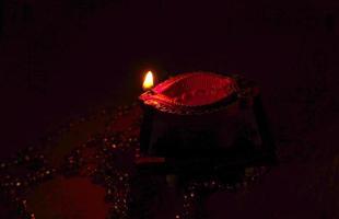 joyeux diwali - lampes diya allumées pendant la célébration de diwali. Des lanternes colorées et décorées sont allumées la nuit à cette occasion avec des rangoli de fleurs, des bonbons et des cadeaux. photo
