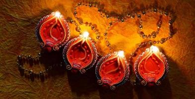 joyeux diwali - lampes diya allumées pendant la célébration de diwali. Des lanternes colorées et décorées sont allumées la nuit à cette occasion avec des rangoli de fleurs, des bonbons et des cadeaux. photo