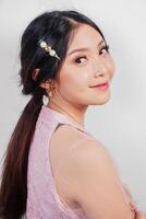 portrait de une Jeune magnifique asiatique femme portant une rose robe, beauté tirer concept photo