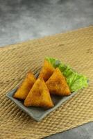 indonésien collations risoles Triangles recouvert avec chapelure rempli avec des légumes et servi chaud photo