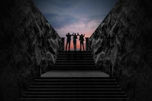 concept de réussite et de travail d'équipe, hommes d'affaires en costume debout au sommet d'un escalier et regardant le ciel