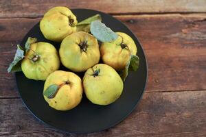 coing fruit. encore la vie sur une en bois Contexte. mûr coing des fruits. photo