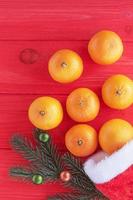 composition du nouvel an et de noël. bonnet de noel, mandarines et branche d'arbre de noël dans les jouets. photo