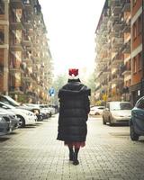 une femme marche dans la rue pendant la quarantaine avec des voitures et des maisons en arrière-plan. quarantaine en georgia.saburtalo. mode de vie urbain en hiver 2020. photo