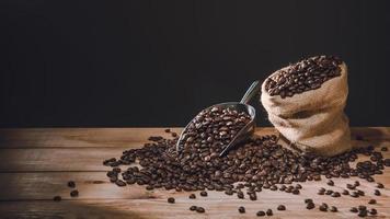 tasse à café et grains de café répartis sur la table en bois ancien avec des copies pour votre texte photo