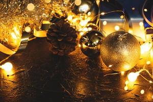 boules de décoration de noël sur fond noir abstrait bokeh avec espace de copie et lumières LED décoratives. joyeux noël et nouvel an. photo