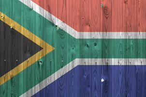 Sud Afrique drapeau représenté dans brillant peindre couleurs sur vieux en bois mur. texturé bannière sur rugueux Contexte photo