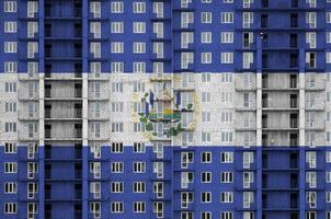 el Salvador drapeau représenté dans peindre couleurs sur à plusieurs étages résidentielle bâtiment en dessous de construction. texturé bannière sur brique mur Contexte photo