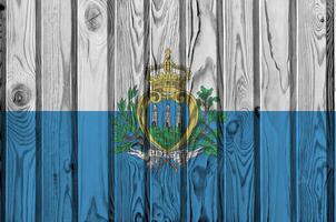 san marino drapeau représenté dans brillant peindre couleurs sur vieux en bois mur. texturé bannière sur rugueux Contexte photo