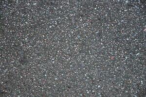surface grunge rugueux de asphalte. macadam foncé gris granuleux route. texture Contexte Haut vue photo
