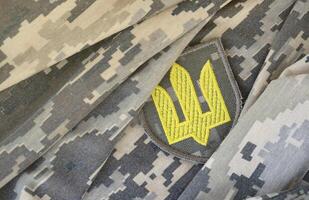 symbole de ukrainien armée sur le camouflage uniforme de une ukrainien soldat. le concept de guerre dans Ukraine, patriotisme et protéger votre pays de occupants photo