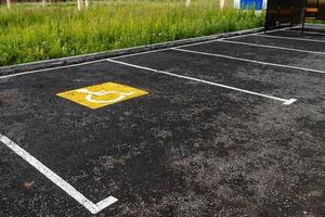 une Jaune signe sur le asphalte spectacles une parking endroit pour gens avec handicapées, pour le désactivé, une route signe, marquages sur le route photo