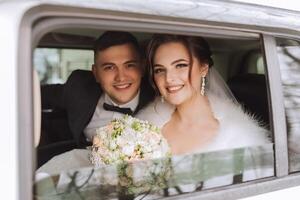 magnifique la mariée et jeune marié à la recherche à le caméra tandis que séance dans une élégant blanc auto. magnifique mariage. souriant mariage couple photo