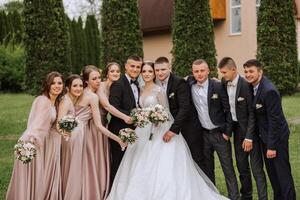 toute la longueur portrait de le jeunes mariés et leur copains à le mariage. le la mariée et jeune marié avec demoiselles d'honneur et copains de le jeune marié sont ayant amusement et réjouissance à le mariage. photo