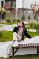 verticale photo. magnifique insouciant Jeune adolescent fille dans décontractée vêtements. portrait de une magnifique fille contre le Contexte de la nature avec une flou Contexte. photo