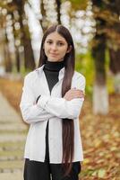 verticale photo. magnifique insouciant Jeune adolescent fille dans décontractée vêtements. portrait de une magnifique fille contre le Contexte de la nature avec une flou Contexte. photo