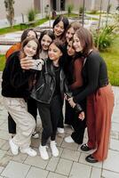 copains prise une gros groupe selfie souriant à le caméra - en riant Jeune gens permanent en plein air et ayant amusement - portrait de de bonne humeur écoliers à l'extérieur école - Humain Ressources concept photo