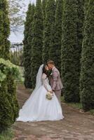 mariage. l'amour et couple dans jardin pour mariage. fête de la cérémonie et engagement. enregistrer le date. confiance. le la mariée et jeune marié embrasser. sourire et l'amour. photo de content et dans l'amour les mariées et les palefreniers.