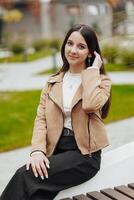 verticale photo. magnifique insouciant Jeune adolescent fille dans décontractée vêtements. portrait de une magnifique fille contre le Contexte de la nature avec une flou Contexte. photo