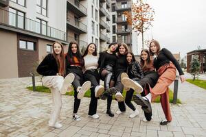 groupe de beaucoup content adolescents habillé dans décontractée vêtements ayant amusement et ayant amusement près collège. concept de amitié, des moments de Bonheur. école relation amicale photo