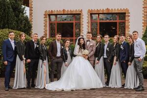 toute la longueur portrait de le jeunes mariés et leur copains à le mariage. le la mariée et jeune marié avec demoiselles d'honneur et copains de le jeune marié sont ayant amusement et réjouissance à le mariage. photo