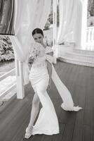 portrait de le la mariée dans une mariage robe avec une bouquet de fleurs dans sa mains. noir et blanc photo