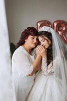 une magnifique et content mère et sa fille, le mariée, sont permanent suivant à chaque autre. le meilleur journée pour parents. soumissionner des moments à le mariage. photo