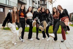 groupe de beaucoup content adolescents habillé dans décontractée vêtements ayant amusement et ayant amusement près collège. concept de amitié, des moments de Bonheur. école relation amicale photo