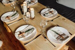 magnifique table réglage et coutellerie sur une en bois table à une mariage ou dîner. élégant table décorations photo