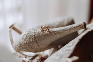 détails de le la mariée. beauté est dans le détails. talon haut de mariée chaussures. or mariage bague avec une diamant. parfums. des boucles d'oreilles mariage dans détails. photo