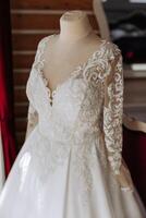 chambre intérieur avec mariage robe préparé pour le cérémonie. une magnifique luxuriant mariage robe sur une mannequin dans une Hôtel chambre. photo