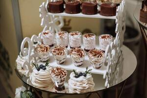 amande biscuits et divers sucré Gâteaux pour une mariage banquet. une délicieux réception, une luxueux cérémonie. table avec bonbons et desserts. délicieux coloré français desserts sur une assiette ou tableau. photo