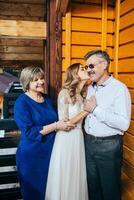 content Parents réjouir pour leur fille, qui volonté bientôt avoir marié. émouvant des moments à le mariage. maman et papa étreinte fille la mariée. portrait de Parents avec la mariée photo