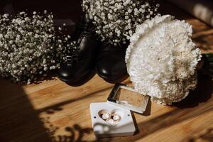 Pour des hommes accessoires, jeune marié détails. beauté est dans le détails. préparation pour le mariage. cuir chaussures. or mariage anneaux. arc cravate. mariage bouquet de fleurs. photo