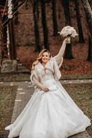 magnifique la mariée avec une mariage bouquet de fleurs, attrayant femme dans une mariage robe avec une longue voile. content la mariée femme. la mariée avec mariage maquillage et coiffure. hiver mariage photo