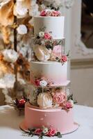 une à plusieurs niveaux mariage gâteau dans le banquet entrée, décoré avec Frais fleurs. préparation pour le mariage fête. Coupe le mariage gâteau. photo