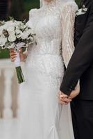 le la mariée et jeune marié doucement tenir mains. tondu photo. magnifique cheveux et se maquiller. un exquis mariage photo