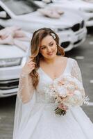 portrait de une magnifique la mariée avec une mariage bouquet de fleurs, attrayant femme dans une mariage robe avec une longue voile. content la mariée femme. la mariée avec mariage maquillage et coiffure. hiver mariage photo