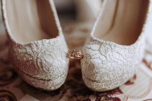 détails de le la mariée. beauté est dans le détails. talon haut de mariée chaussures. or mariage bague avec une diamant. parfums. des boucles d'oreilles mariage dans détails. photo