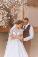 mariage. l'amour et couple dans jardin pour mariage. fête de la cérémonie et engagement. enregistrer le date. confiance. le la mariée et jeune marié embrasser. sourire et l'amour dans le parc. le jeune marié embrasse le la mariée. photo