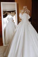 chambre intérieur avec mariage robe préparé pour le cérémonie. une magnifique luxuriant mariage robe sur une mannequin dans une Hôtel chambre. photo