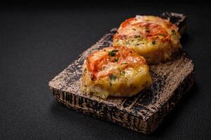 délicieux cuit poisson filet avec fromage, tomates, sel, épices et herbes photo