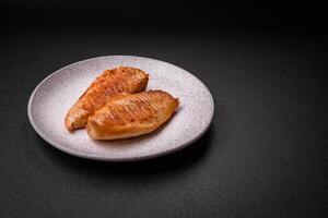 délicieux filet de poulet grillé frais avec des épices et des herbes sur un fond de béton foncé photo