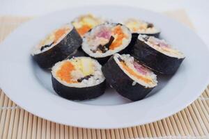 Sushi Rouleaux sur une assiette sur une blanc Contexte. Japonais nourriture photo