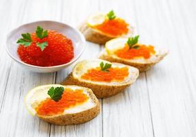 caviar rouge dans un bol et des sandwichs photo