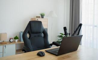 ai généré proche en haut vue de table de travail lieu de travail avec portable et blanc filtrer, microphone pour diffusion ou jeu, carnet de notes, et décoration dans Accueil Bureau chambre. travail à Accueil endroit dans le vivant chambre. photo